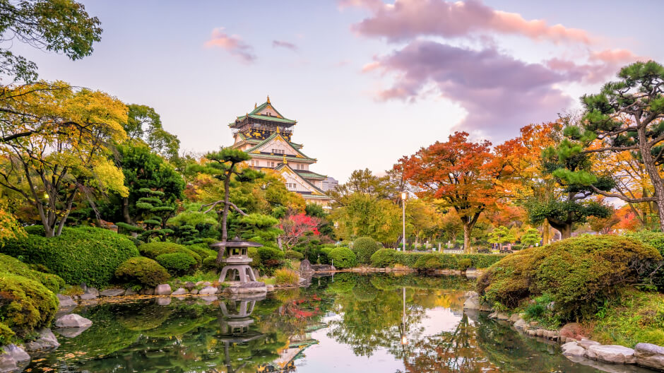 A temple in front of a serene pond in Osaka, Japan