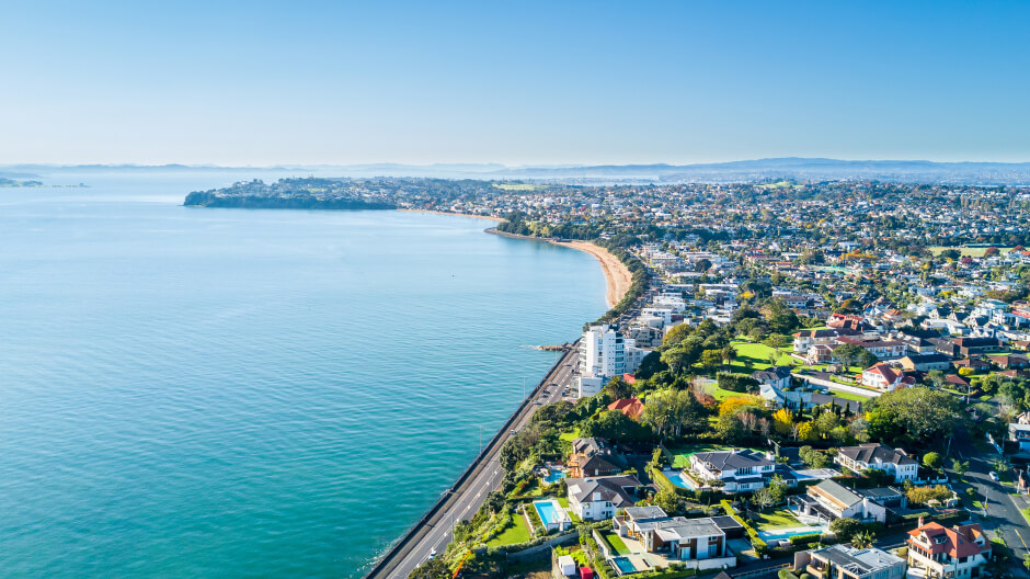 A bird-eye view of a long road along the seashore in Aukland, New Zealand