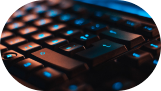 A close-up of a backlit keyboard with blue and orange lighting